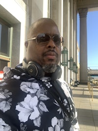 a man wearing headphones and a floral shirt